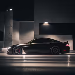 a black, sleek sports car is parked in the darkness