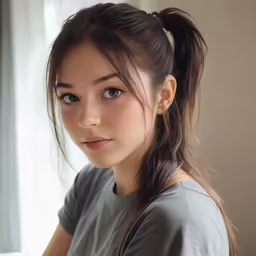 a girl with an updo stands in a darkened room