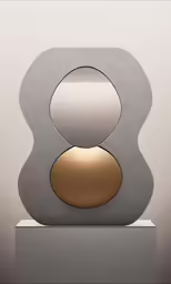 a modern sculpture made from concrete and steel with a circular light