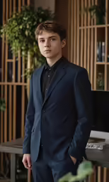 the young man is posing for the camera in the suit
