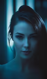 a beautiful young woman in the dark with her long hair pulled back