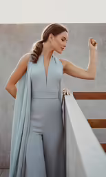a woman posing in a blue gown on the balcony