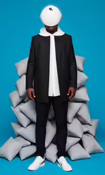 a person standing in front of a bunch of pillows