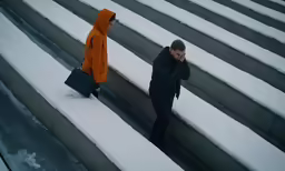 a man is standing near another person in a stadium