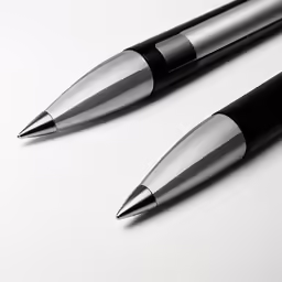 two pens sitting on top of each other next to each other