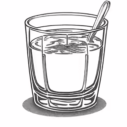 a glass of hot cocoa with a spoon on top