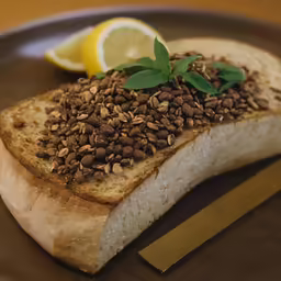 a plate of bread and nuts with a lemon slice