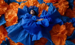 woman dressed in blue and orange dress with flower petals