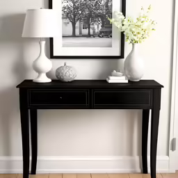 a small table with some flowers and two vases on it