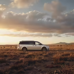 a white van driving on a road near an empty field