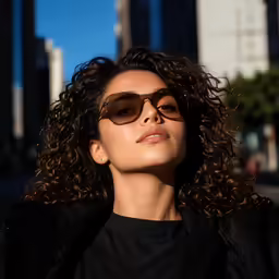 a woman in brown sunglasses and a black top