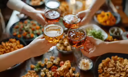 four friends toasting together while holding glasses filled with beer