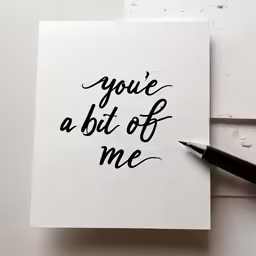 hand lettered tye card and fountain - pen on the left side of a piece of paper