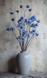 small blue flowers are placed in a vase on a table