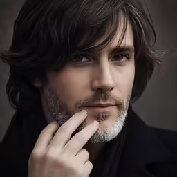 a man with a beard poses for a portrait