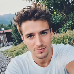 a man poses for the camera in front of some houses