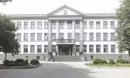 the building has many windows and is white with trim