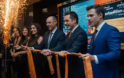 a group of people at an event cutting the ribbon